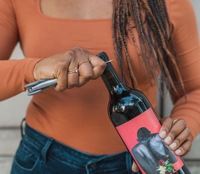 woman opens wine bottle