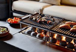 This Fire Pit Table Keeps You Warm and Cooks Your Food